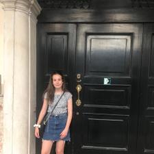 Clara standing by black door