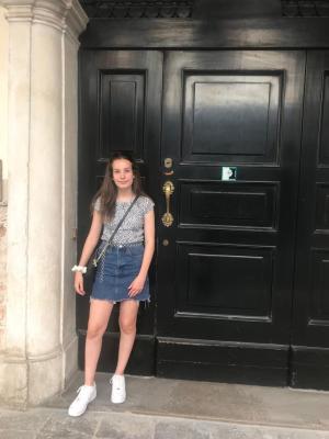 Clara standing by black door